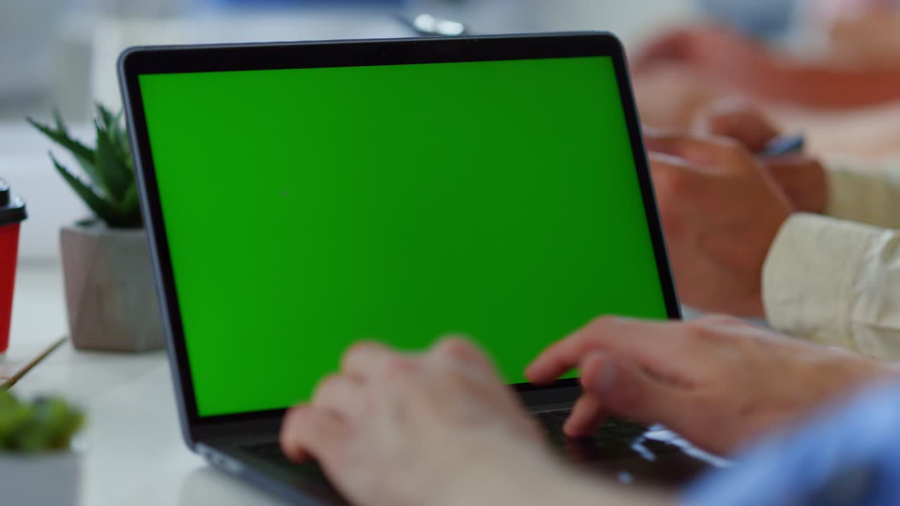 manos de un hombre escribiendo en una computadora portátil de pantalla verde. hombre de negocios desconocido trabajando en una computadora.