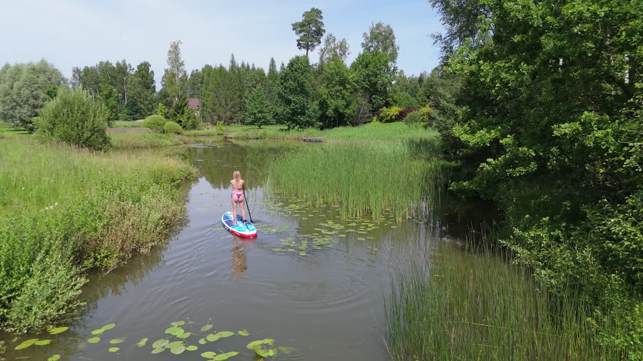 Flying Above Young Woman Stand Up Paddling on Sup Board on Pond in Summer