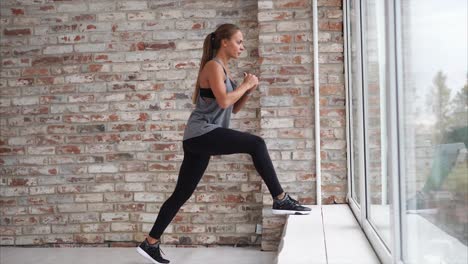 woman doing lunges near a window