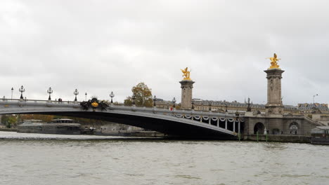 esculturas de fames doradas en los contrapesos del zócalo del puente alejandro iii, parís