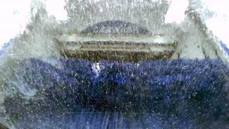 an automatic drive through car wash operating and seen from inside a vehicle