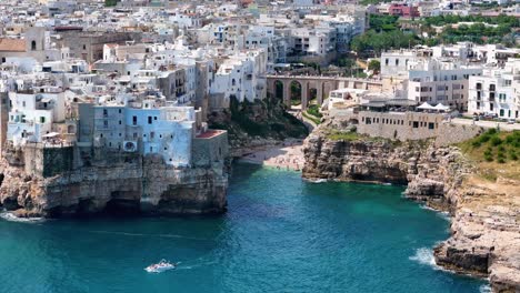 이탈리아 폴리냐노 아 마레 (polignano a mare) 의 아름다운 라마 모나치레 (lama monachiele) 해변에서 드론이 느리게 나타납니다.