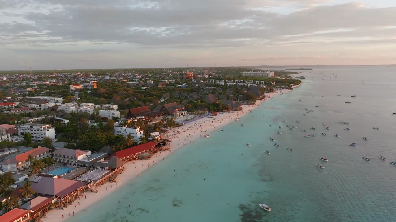 Zanzibar'daki Nungwi Halk Plajı'nın sinematik hava drone çekimi. Beyaz kum, turkuaz su ve tropikal sahil şeridi, seyahat, turizm ve yaşam tarzı projeleri için ideal, canlı ve davetkar bir sahne oluşturuyor