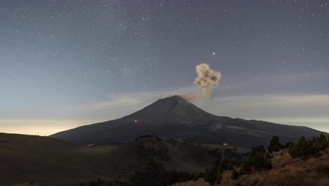 time lapse of popocatepetl active volcano with eruption and fumarole during the night with stars, mexico