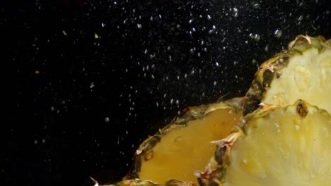 pieces of pineapple falling under water with air bubbles.