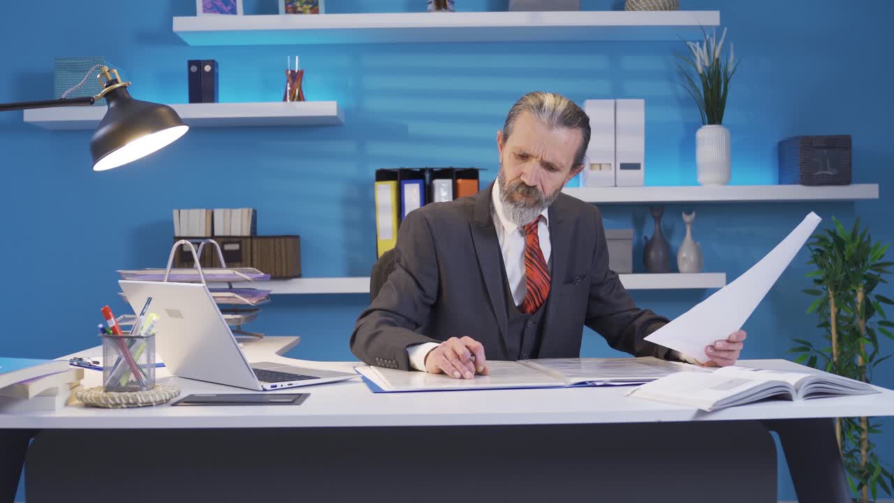 Uomo d'affari maturo di mezza età che pensa a idee creative e geniali e disegna un progetto alla sua scrivania in ufficio