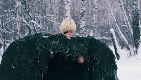 actress in wonderful phoenix suit walks along winter forest