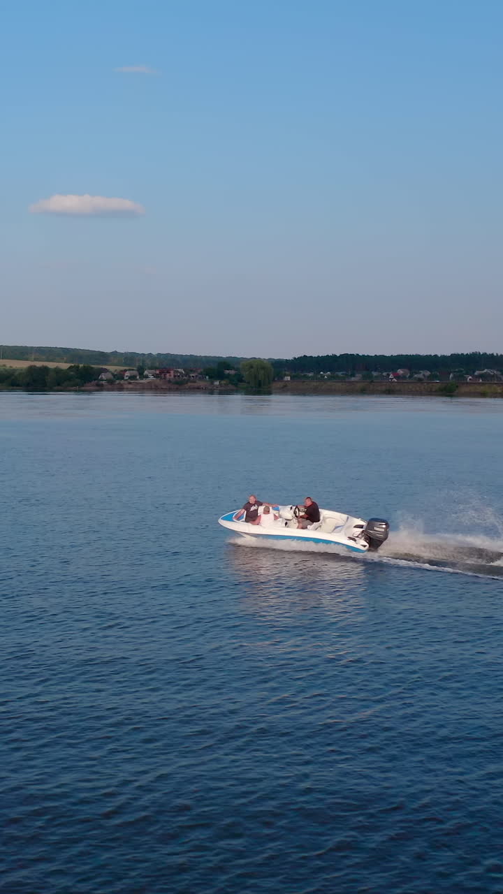 Kiev, Ucraina, 2 maggio 2025: motoscafo naviga lungo il fiume. Vista aerea di un motoscafo che galleggia sul fiume durante le vacanze. Video verticale