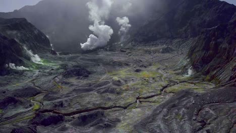 cráter whakaari de la isla blanca con humo tóxico y terreno árido, aéreo