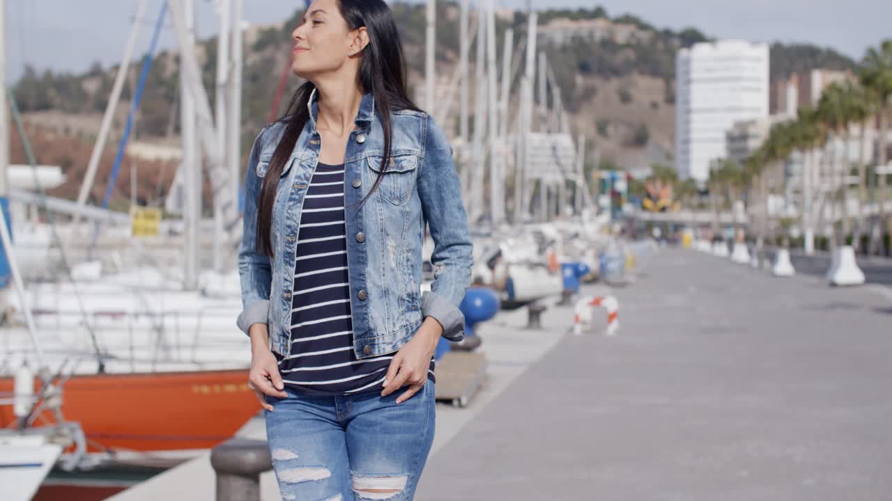 mujer casual disfrutando de un paseo por un puerto deportivo