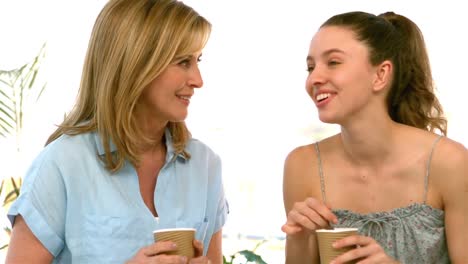 mother and daughter talking and holding glasses