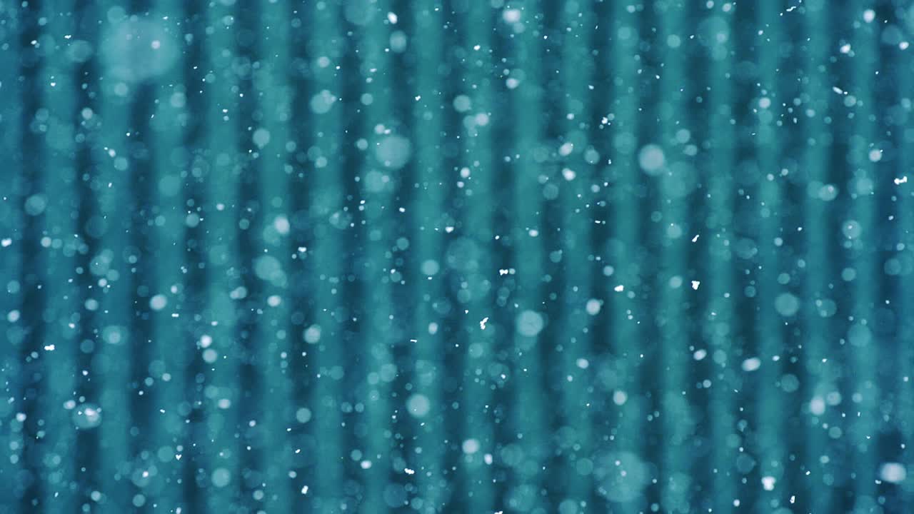 Minimal abstract shot of snow falling over lined blue metal background, daylight