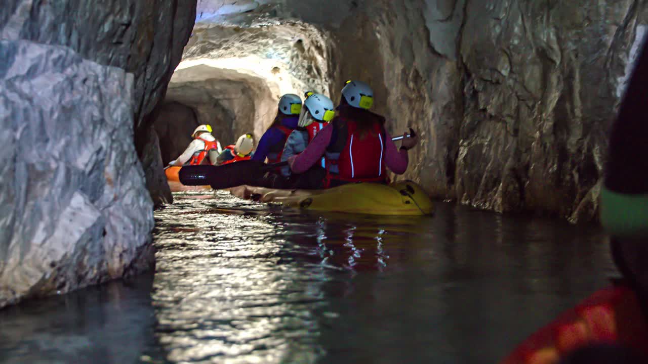 gruppo avventuroso di amici in kayak all'interno di una grotta stretta e buia a Mezica