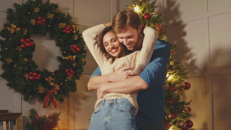 couple hugging by christmas tree