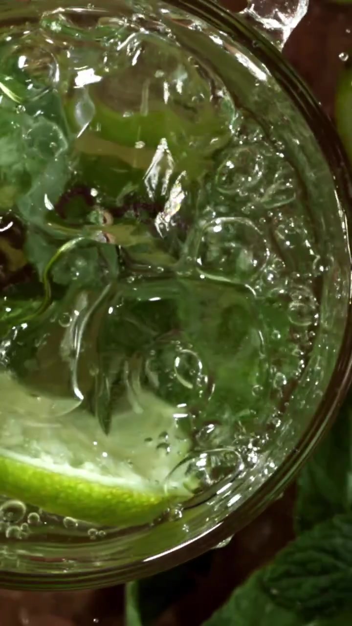 Kuplivaa vettä kaatamassa virkistävään mojitoon mintun ja limen kera