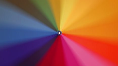 a multi-colored rainbow umbrella rotates