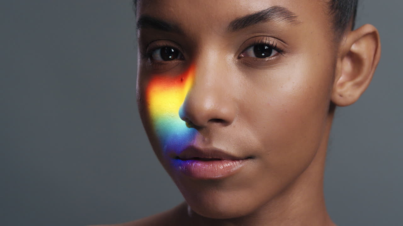 retrato multicolor de cerca hermosa mujer afroamericana con luz colorida que se refleja en una piel suave y saludable mujer atractiva sonriente confiada concepto lgbt
