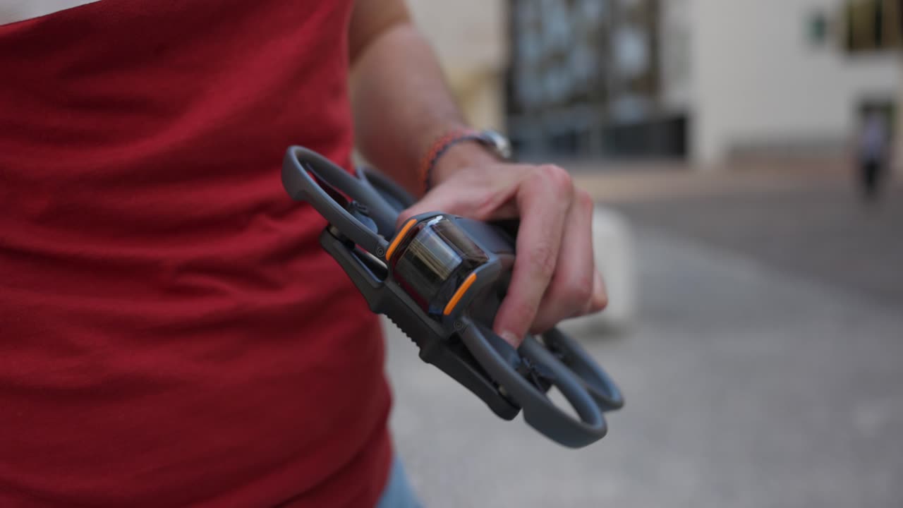 las manos de un hombre vuelven a fijar la cubierta del gimbal a su dron avata - de cerca