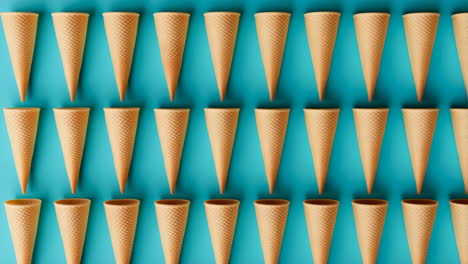 Multiple ice cream waffle cones arranged on a blue background
