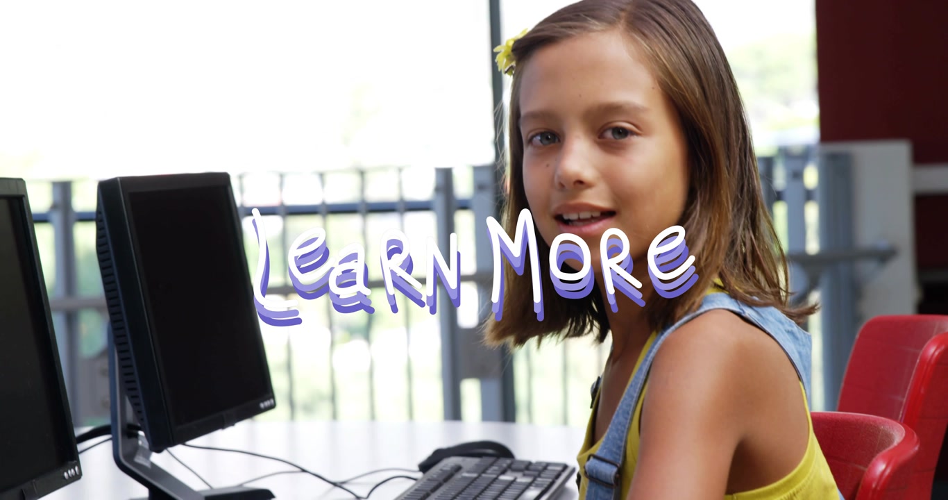 Girl typing on keyboard with monitors, Learn More overlay appearing, pausing smiling, learning