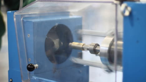 man working on lathe at factory. lathe with protective organic glass