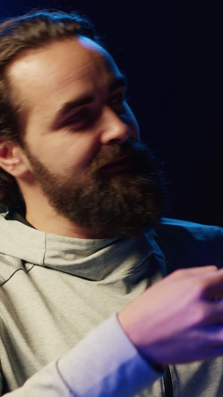 Video verticale: streamer famoso in studio illuminato al neon che chatta con il pubblico