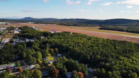 a drone shot of a private airport in new england during the fall time