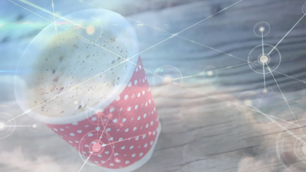 Red and white polka-dot coffee cup being shown in macro, displaying froth with network overlay