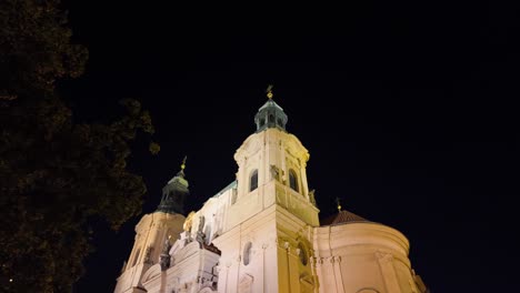 night view of st. nicholas' church in prague, illuminated under the dark sky with baroque elegance
