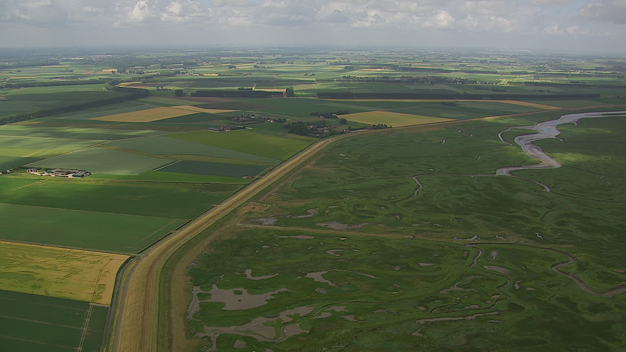 wide angle shot of green landscape in a tidal flood area during daytime showing fertile land.