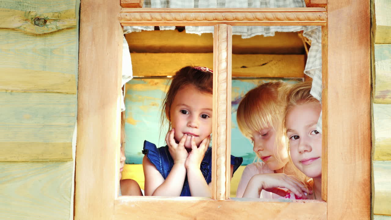 네 명의 소녀가 집 창밖을 내다본다
