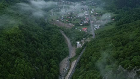 vista aérea sobre las casas de la aldea en el valle en un día de niebla en lepsa, vrancea, rumania - toma de avión no tripulado
