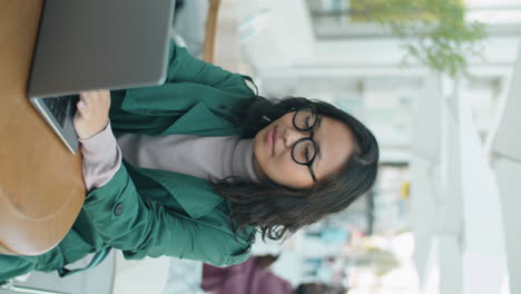 Joven-Empresaria-Asiática-Trabajando-En-Una-Laptop-En-Un-Café-Al-Aire-Libre