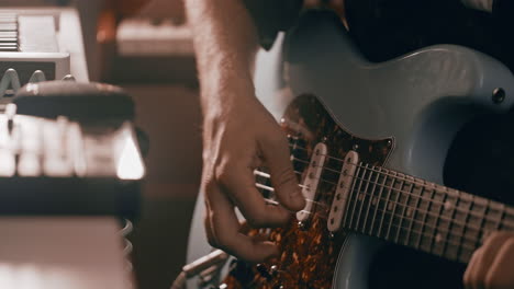 person playing an electric guitar in a recording studio
