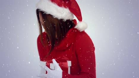 Video-composition-with-falling-snow-over-happy-girl-with--santas-hat