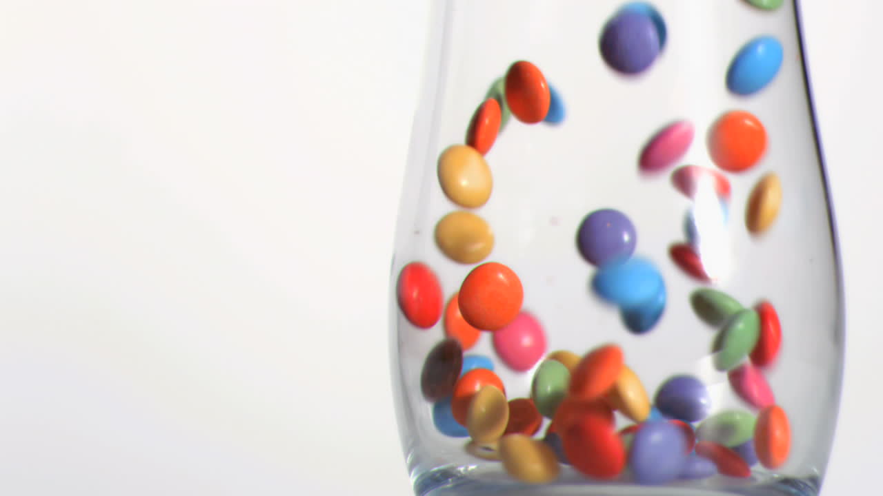 un primer plano de los caramelos que caen en súper cámara lenta