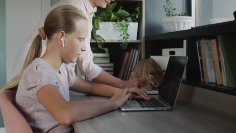 Una-Mujer-Ayuda-A-Una-Adolescente-A-Hacer-Su-Tarea.-Concepto-De-Educación-En-Casa