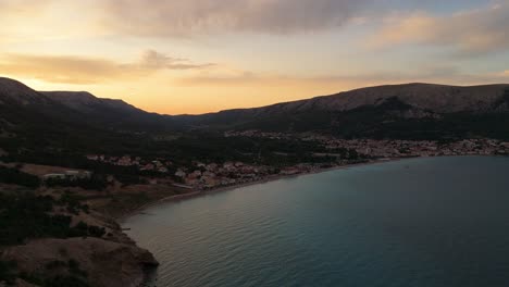 baska beach and coastline with clear turquoise water, marina boats, city street, sunny summer sunset aerial view on krk island, croatia adriatic sea, vela plaza beach, mountains and campsite cityscape