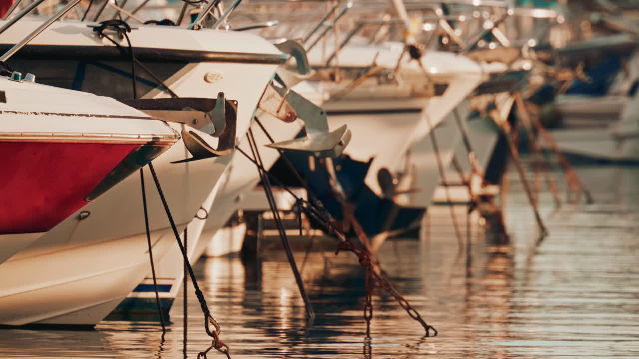 Cinematic shot of a boat propeller near a red hull, reflecting vibrant colors on the water surface