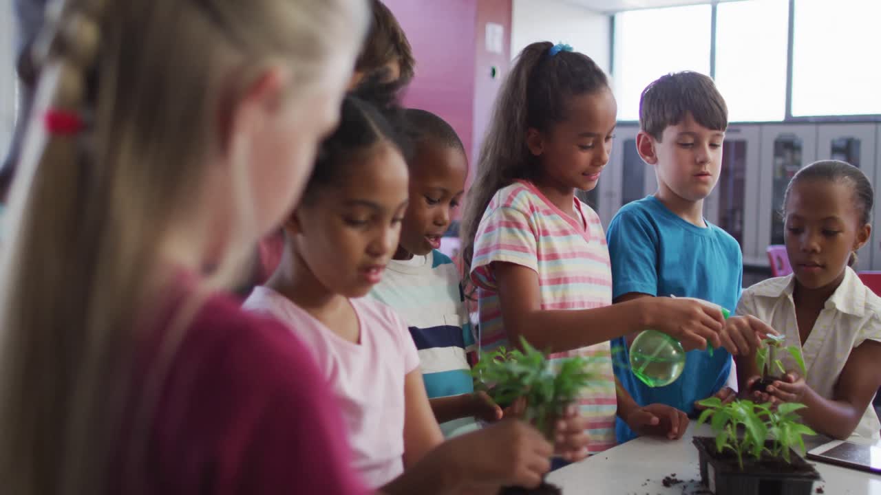 grupo diverso de escolares felices que cuidan las plantas en el aula durante la lección de estudios de naturaleza