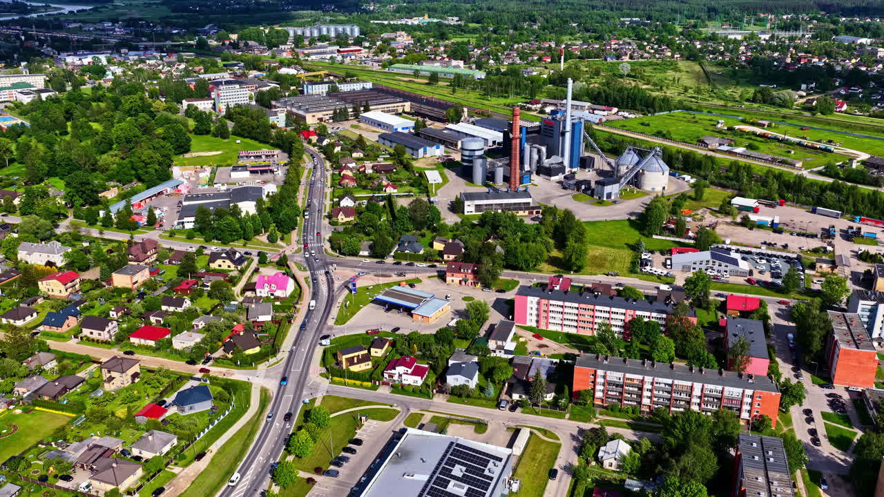 Urban cityscape with roads, residential buildings and industrial plant in background