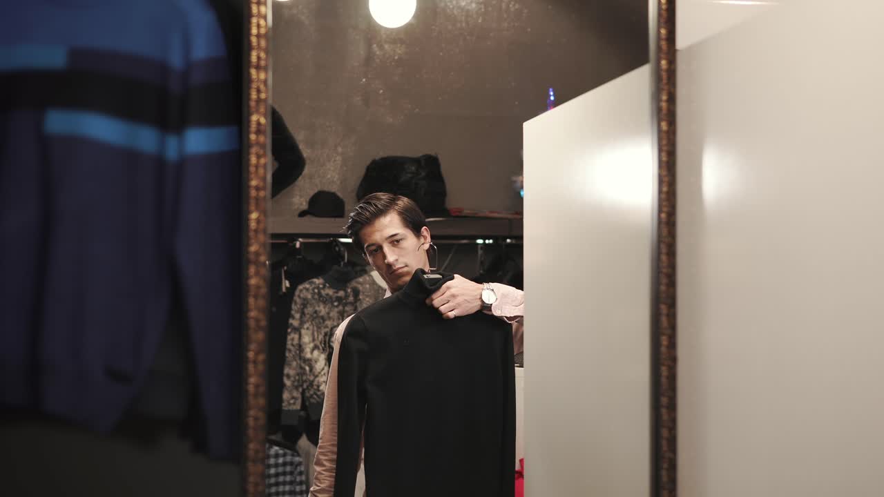 hombre probando ropa en un camerino