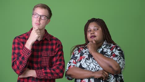 overweight african woman and young scandinavian man together against green background