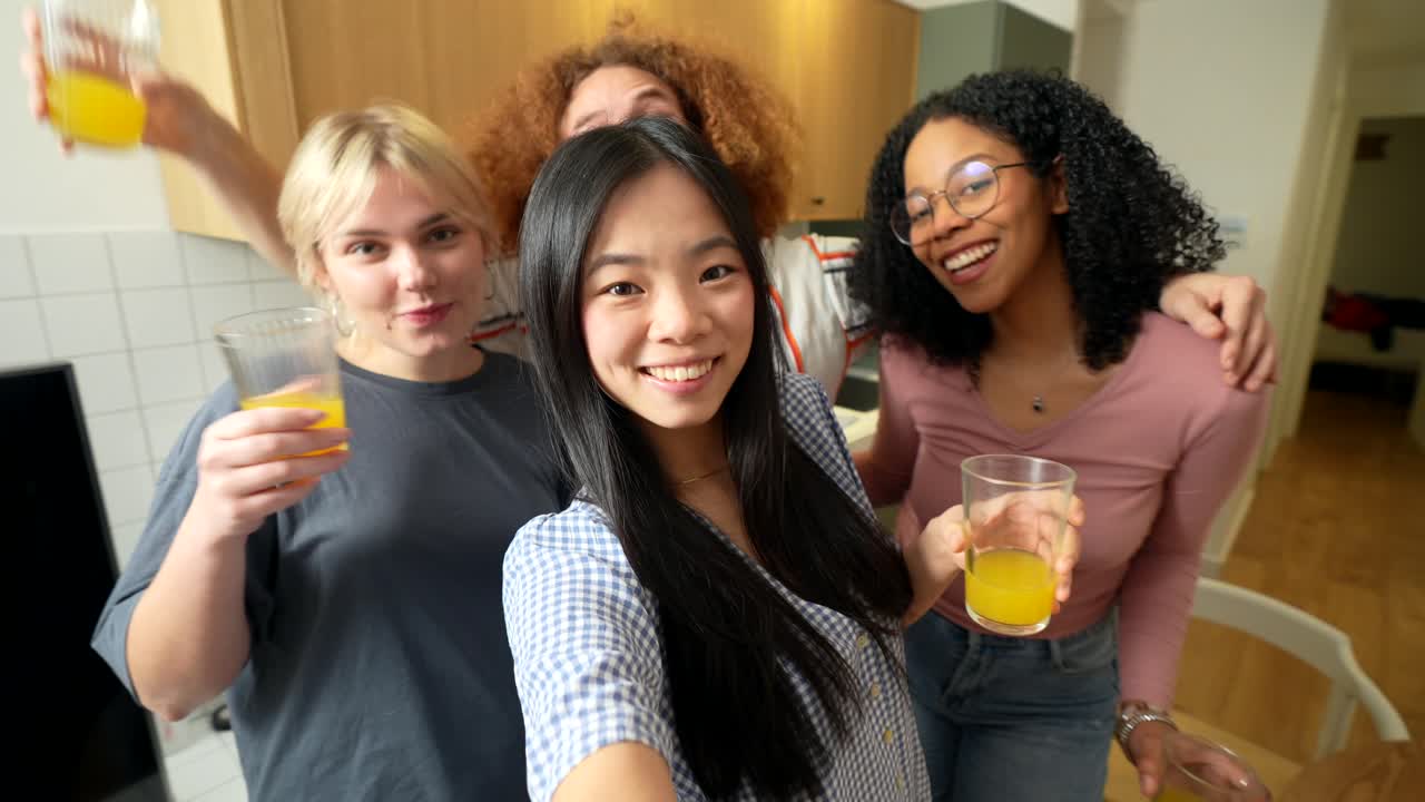 Friends taking a group selfie with orange juice