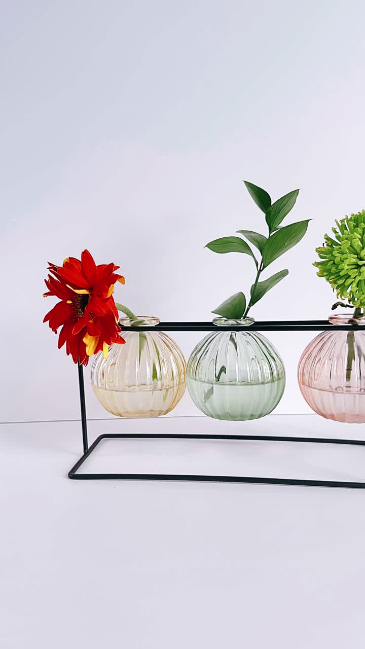 tres jarrones de vidrio de colores con flores