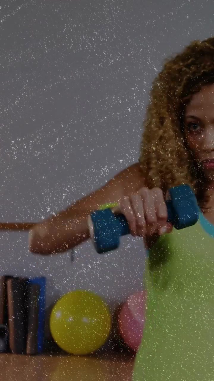 Video verticale: Donna protagonista che entra nell'inquadratura, che tiene manubri e sferra pugni per il fitness vicino alla sbarra.