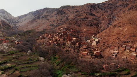 aerial drone view of a remote rural moroccan village located on the high atlas mountains in morocco.camera moving forward from the valley towards the mountain village.