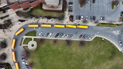 school bus line at school with students leaving building