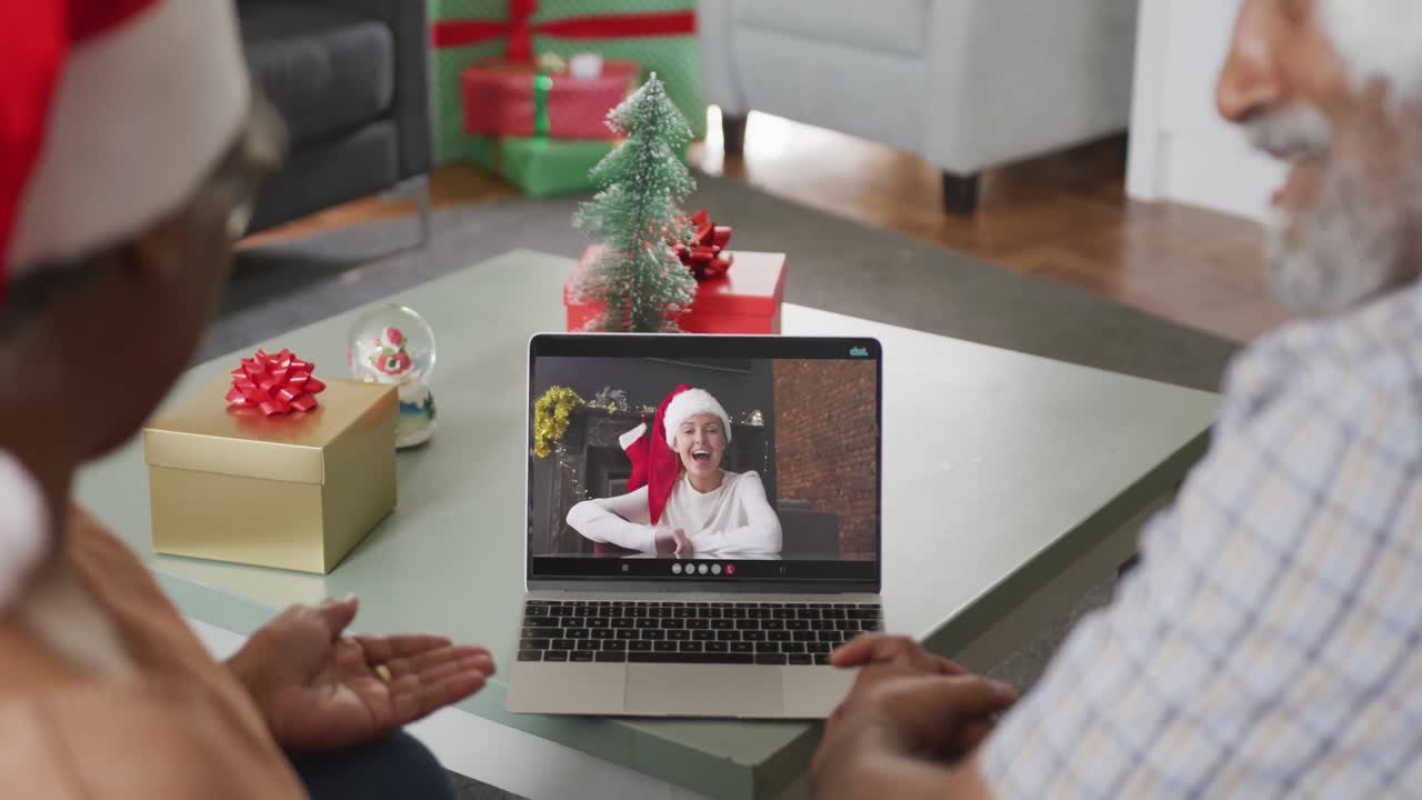 feliz pareja afroamericana senior en videollamada en computadora portátil con una amiga en tiempo de navidad