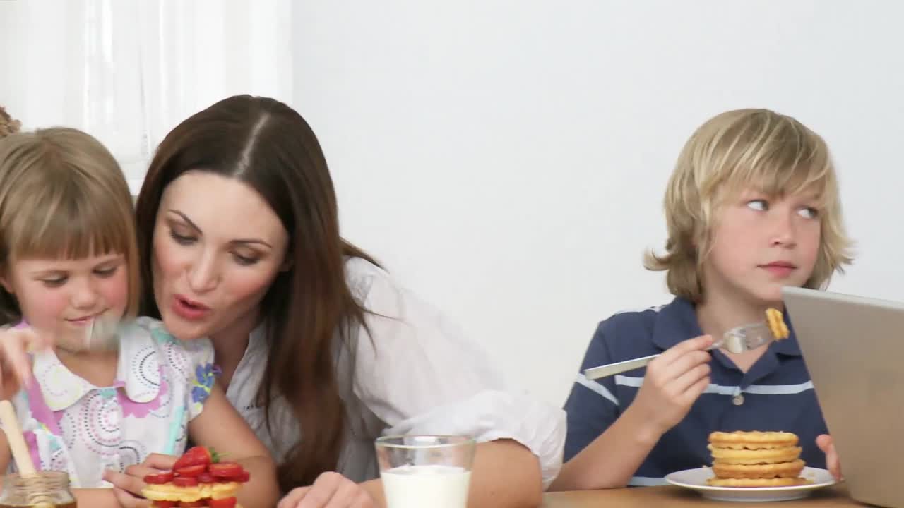 panorama de papá usando una computadora portátil y la familia comiendo dulces en la cocina